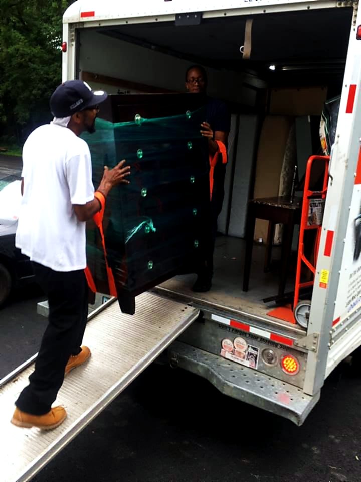 A wrapped dresser riding the liftgate up to the box