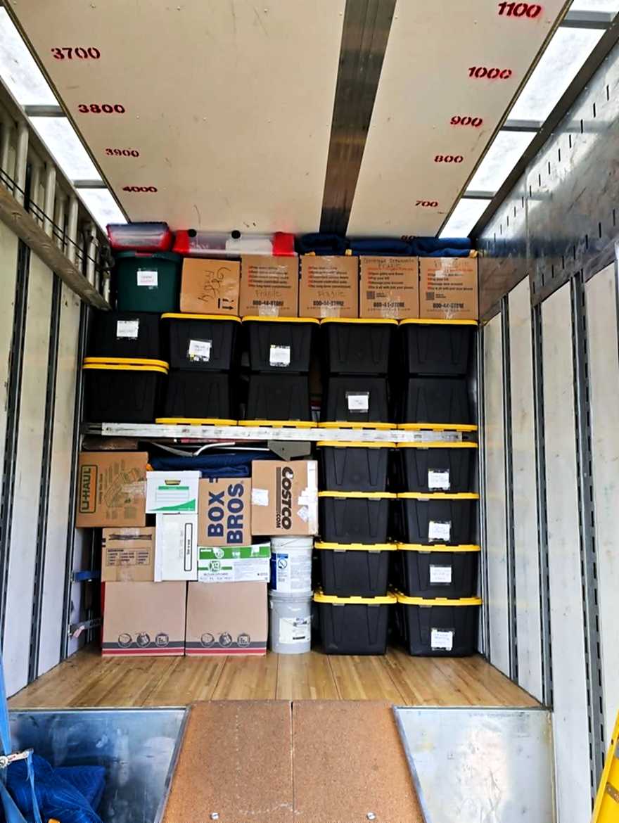 A neatly loaded truck — labelled totes and boxes tiered and secured