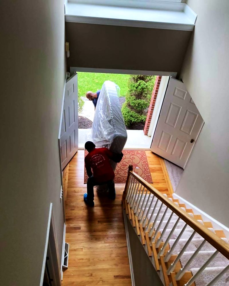 A bagged mattress on its way down the stairs and out the front door