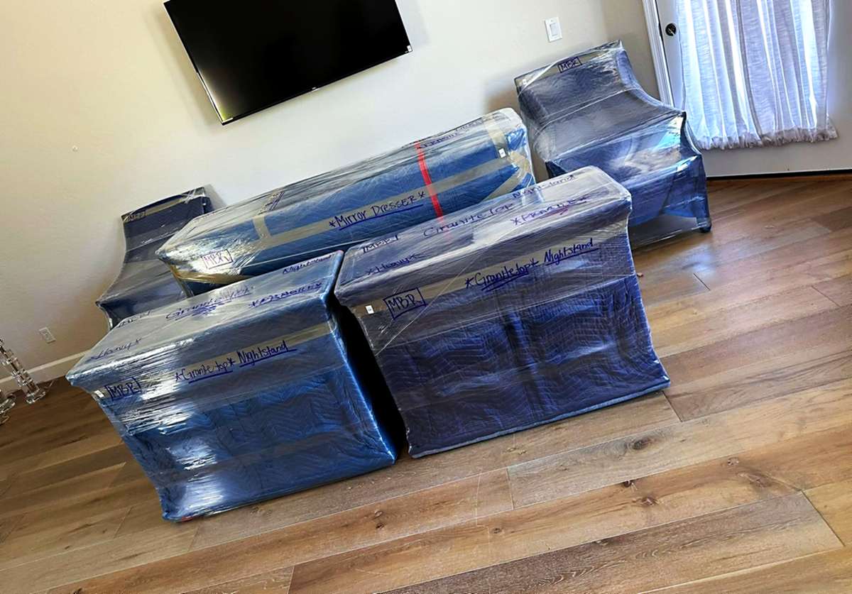 Wrapped furniture staged in a cleared room, ready to load
