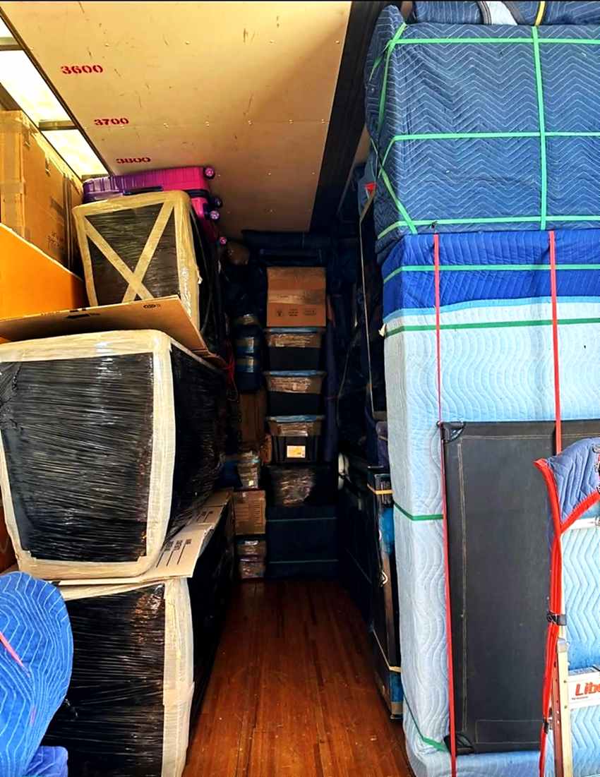 Blanket-wrapped furniture strapped tight against the truck wall